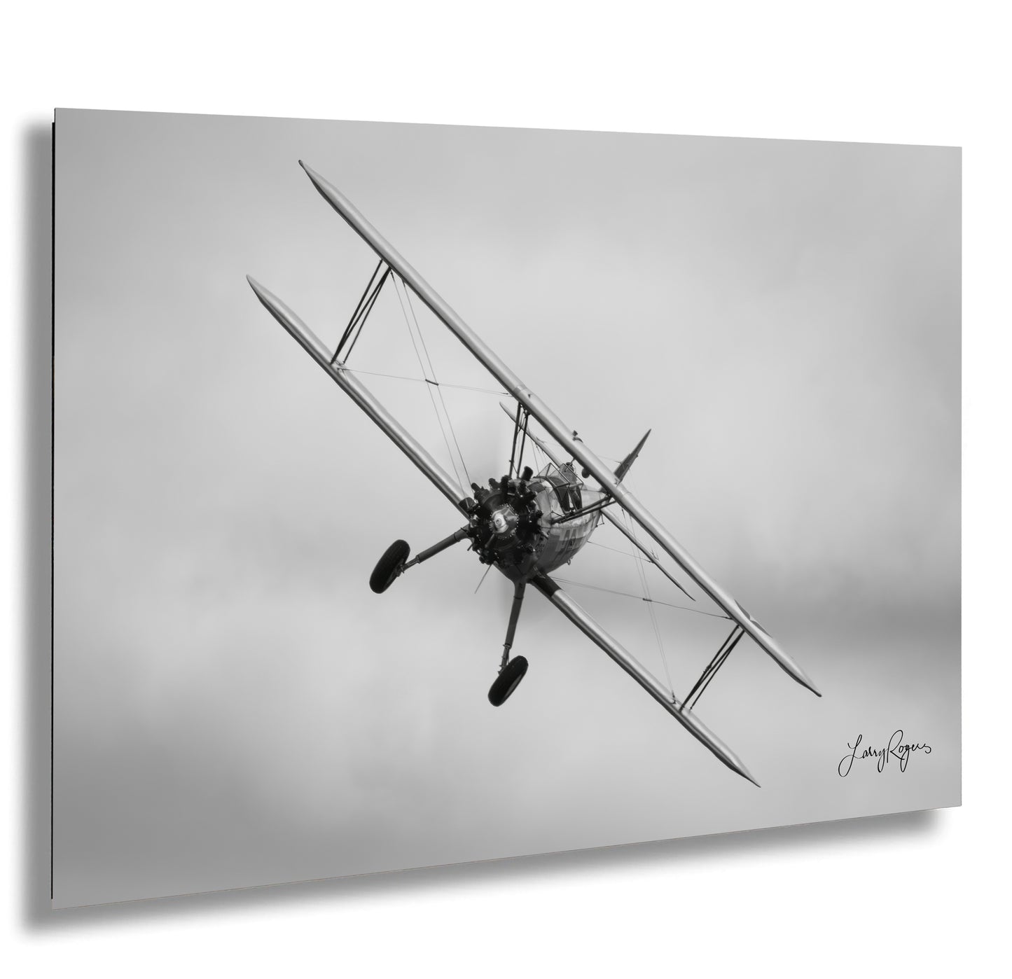 a black and white photo of a biplane flying in the sky