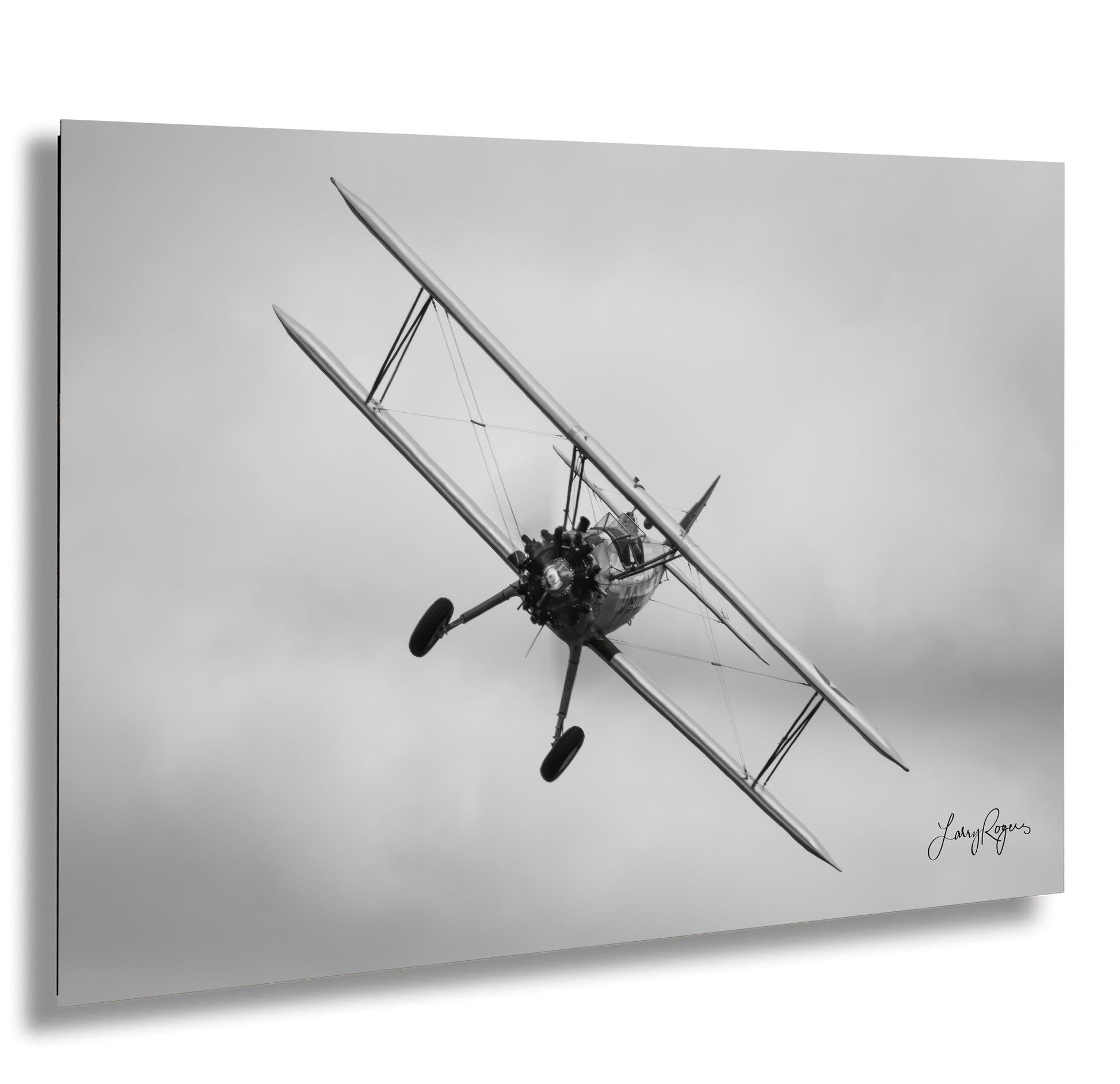 a black and white photo of a biplane flying in the sky
