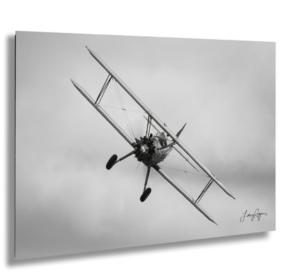 a black and white photo of a biplane flying in the sky