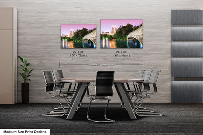 a dining room table with chairs next to a wall with a picture of a bridge