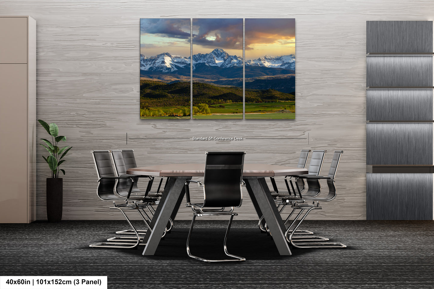 a modern office space with a large, three-panel landscape painting of a mountain range hanging on the wall. The painting is composed of three distinct sections, each depicting a different part of the mountain range. The office space includes a conference table surrounded by chairs, suggesting it is a meeting or collaboration area.