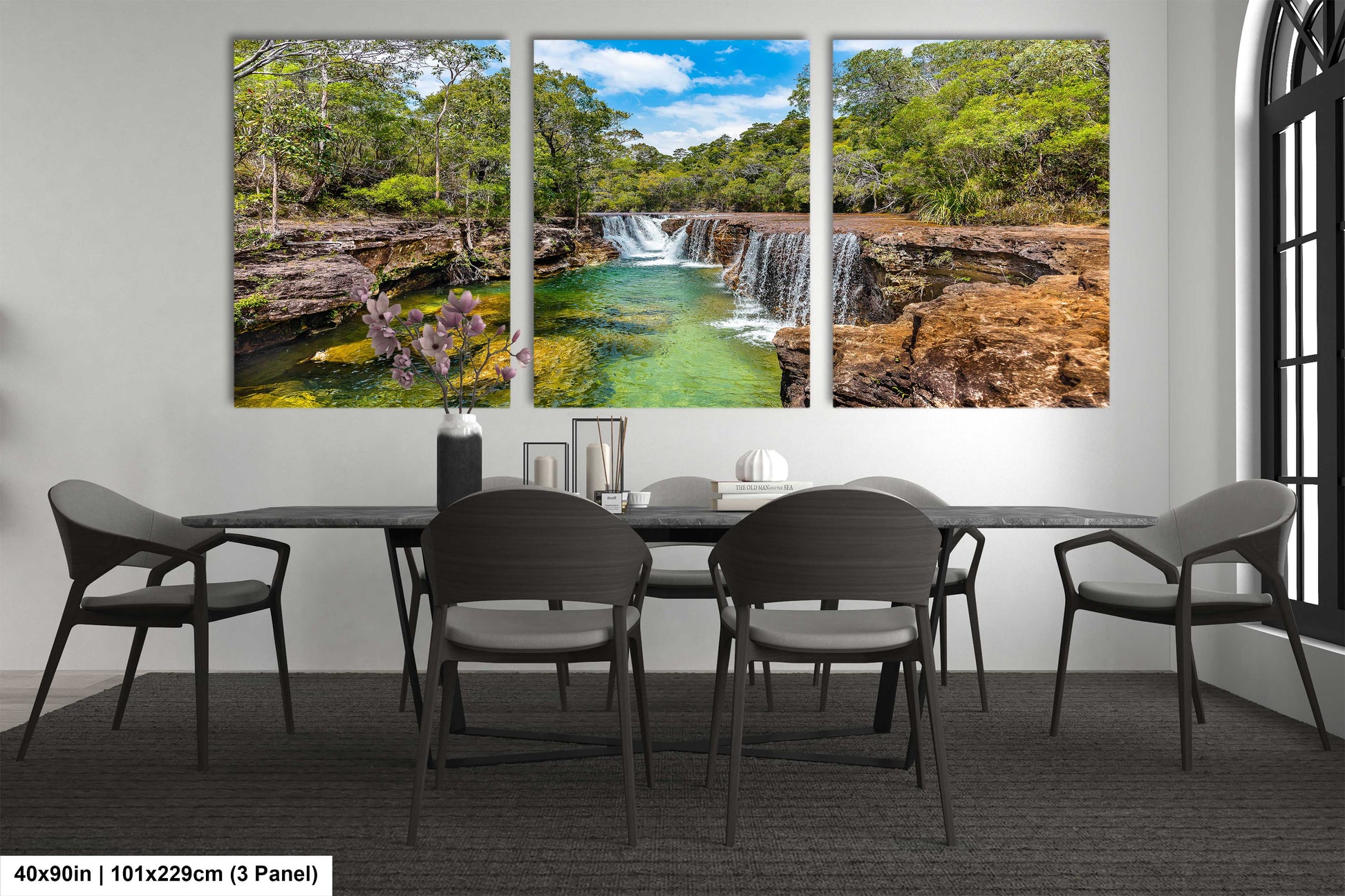a dining room table with four chairs and a painting of a waterfall
