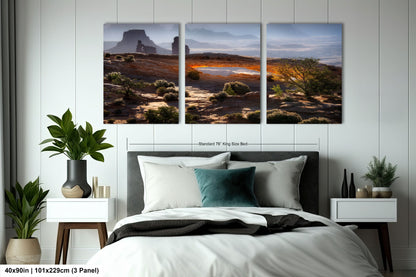 a bedroom with a bed and two paintings on the wall