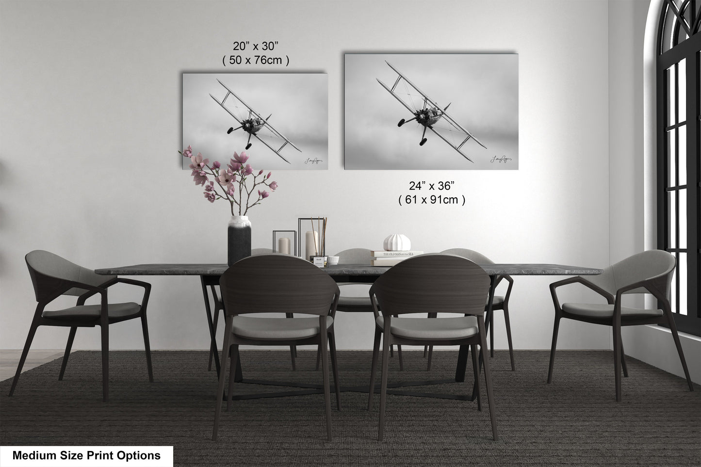a dining table with four chairs and a vase of flowers