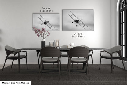 a dining table with four chairs and a vase of flowers