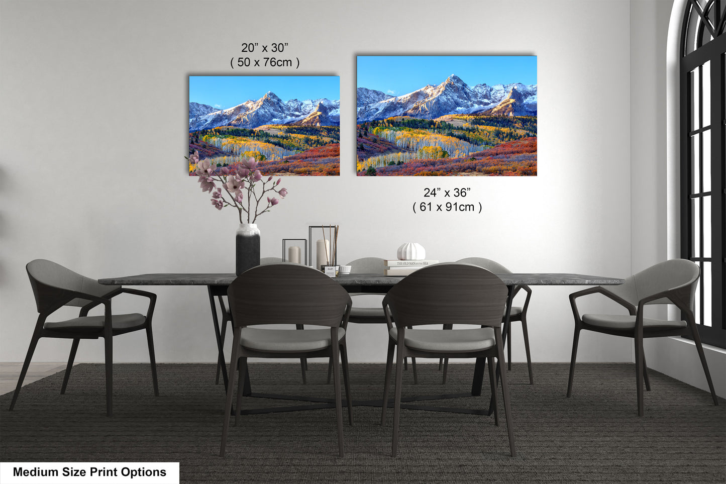 a dining room table with four chairs and a vase with flowers