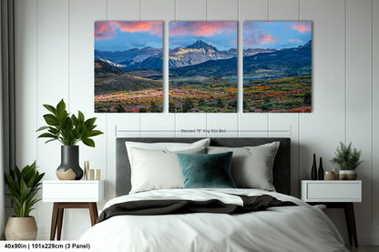 a bedroom scene with a bed and two paintings on the wall