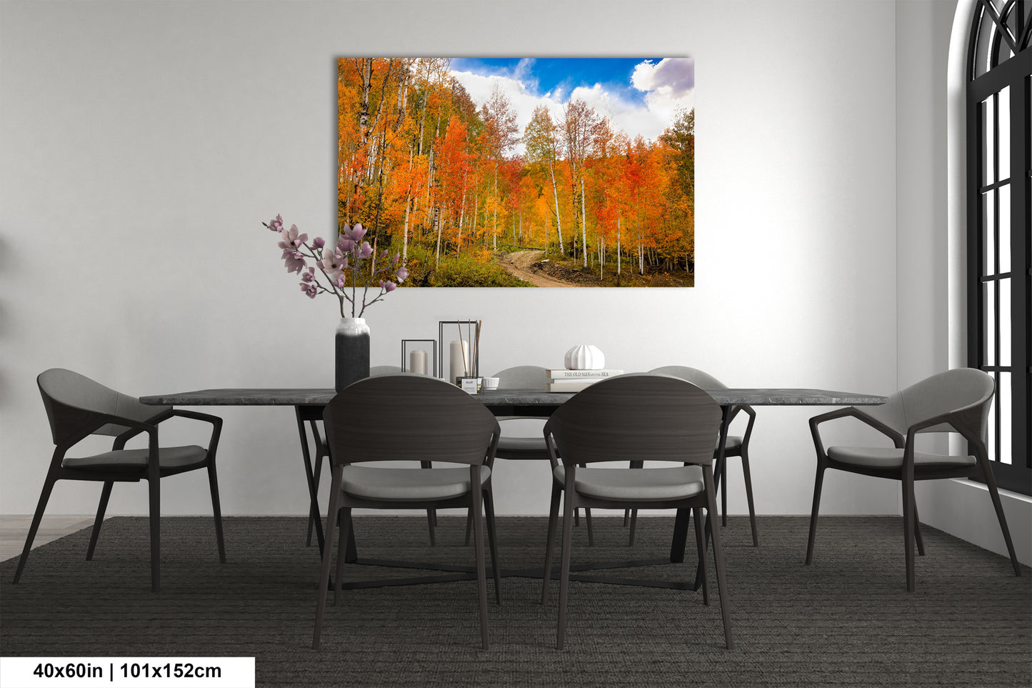a dining room table with chairs and a painting on the wall