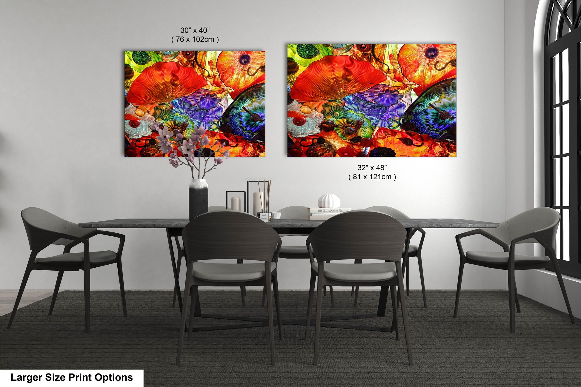 a dining room table with four chairs and two paintings on the wall