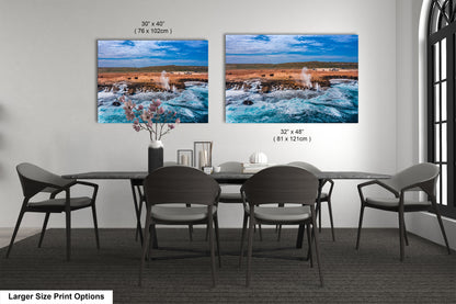 a dining room table with four chairs and two pictures on the wall