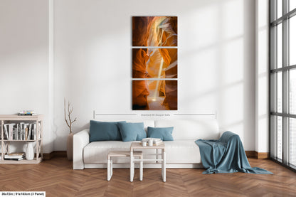a living room with a white couch and a painting on the wall