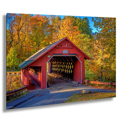 a red covered bridge in a wooded area