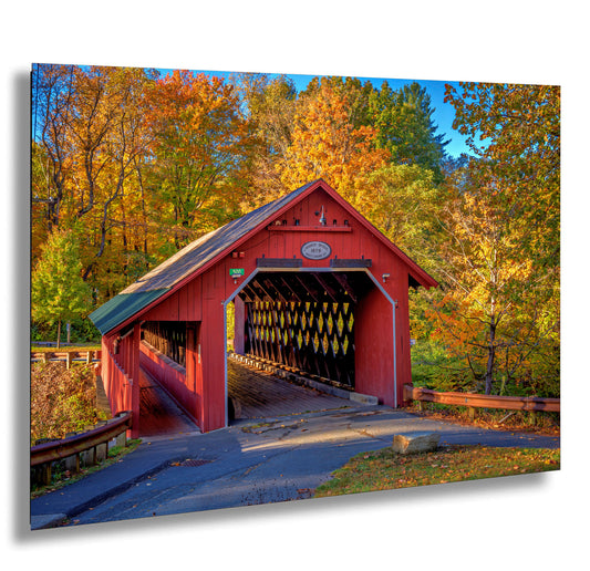 a red covered bridge in a wooded area
