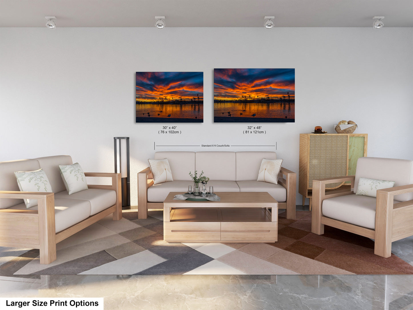 a modern living room with a large sofa, two chairs, and a coffee table. The room has a neutral color scheme with a geometric patterned rug on the floor. Two framed prints of a sunset landscape are displayed on the wall above the seating area.