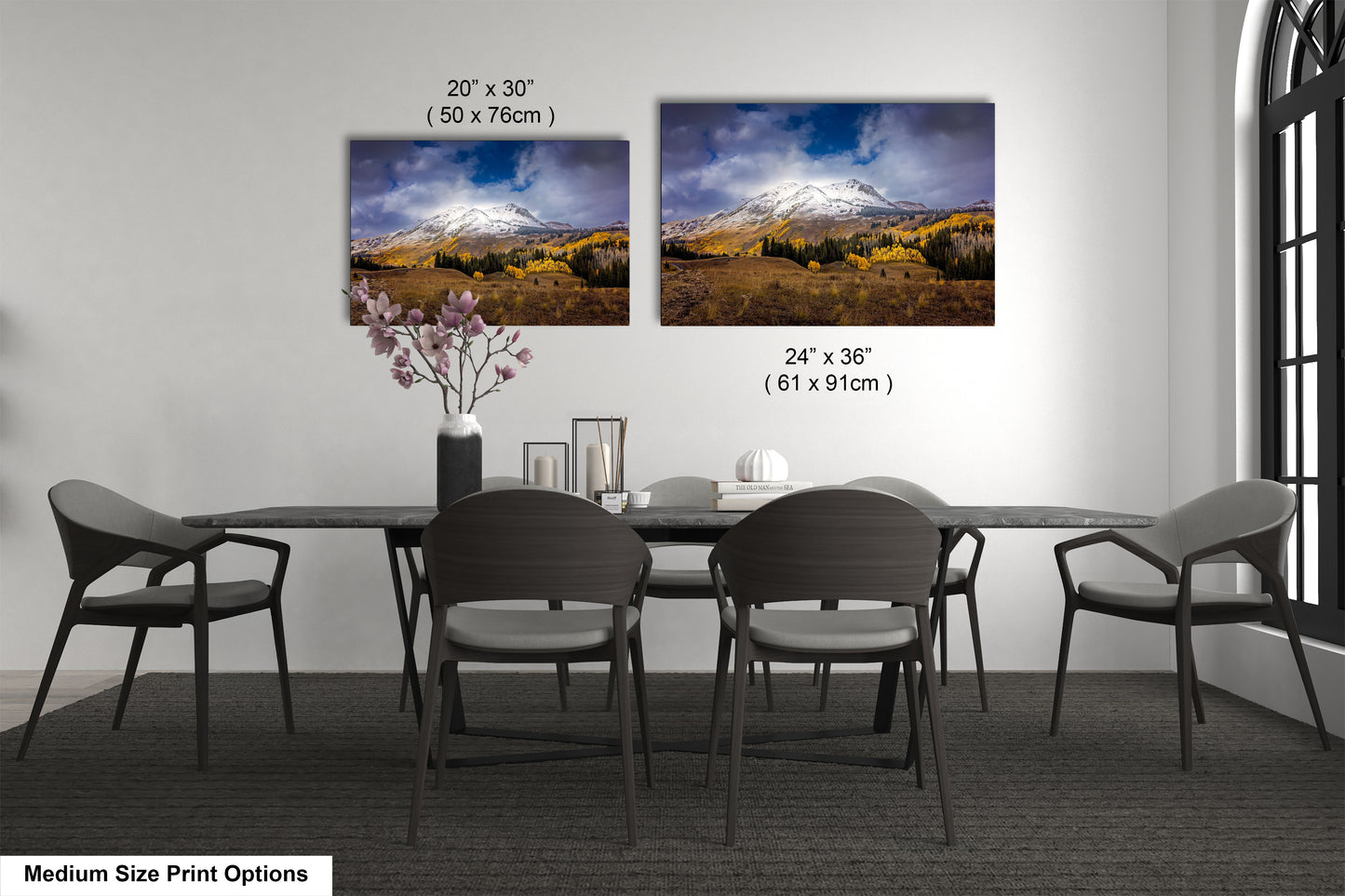 a dining room table with four chairs and a vase with flowers