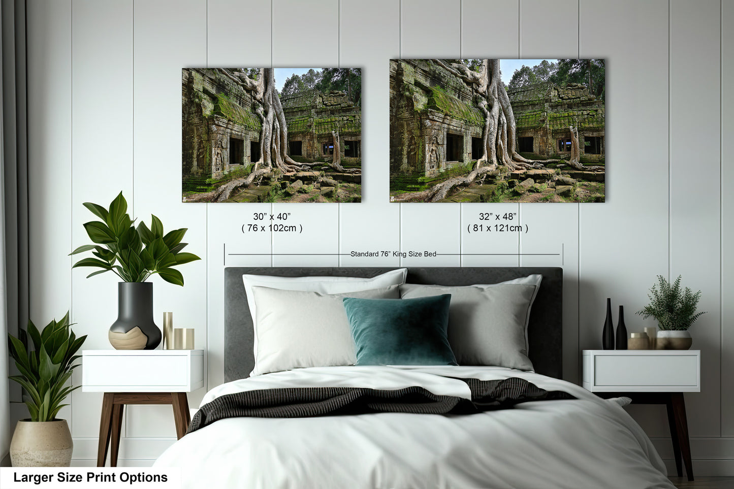 a bed with two pictures of trees on the wall above it