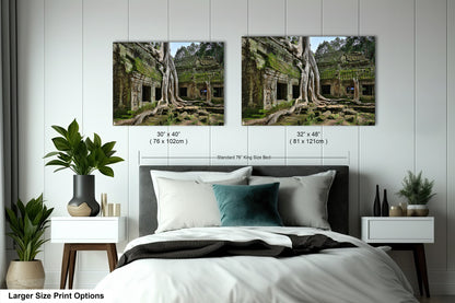 a bed with two pictures of trees on the wall above it