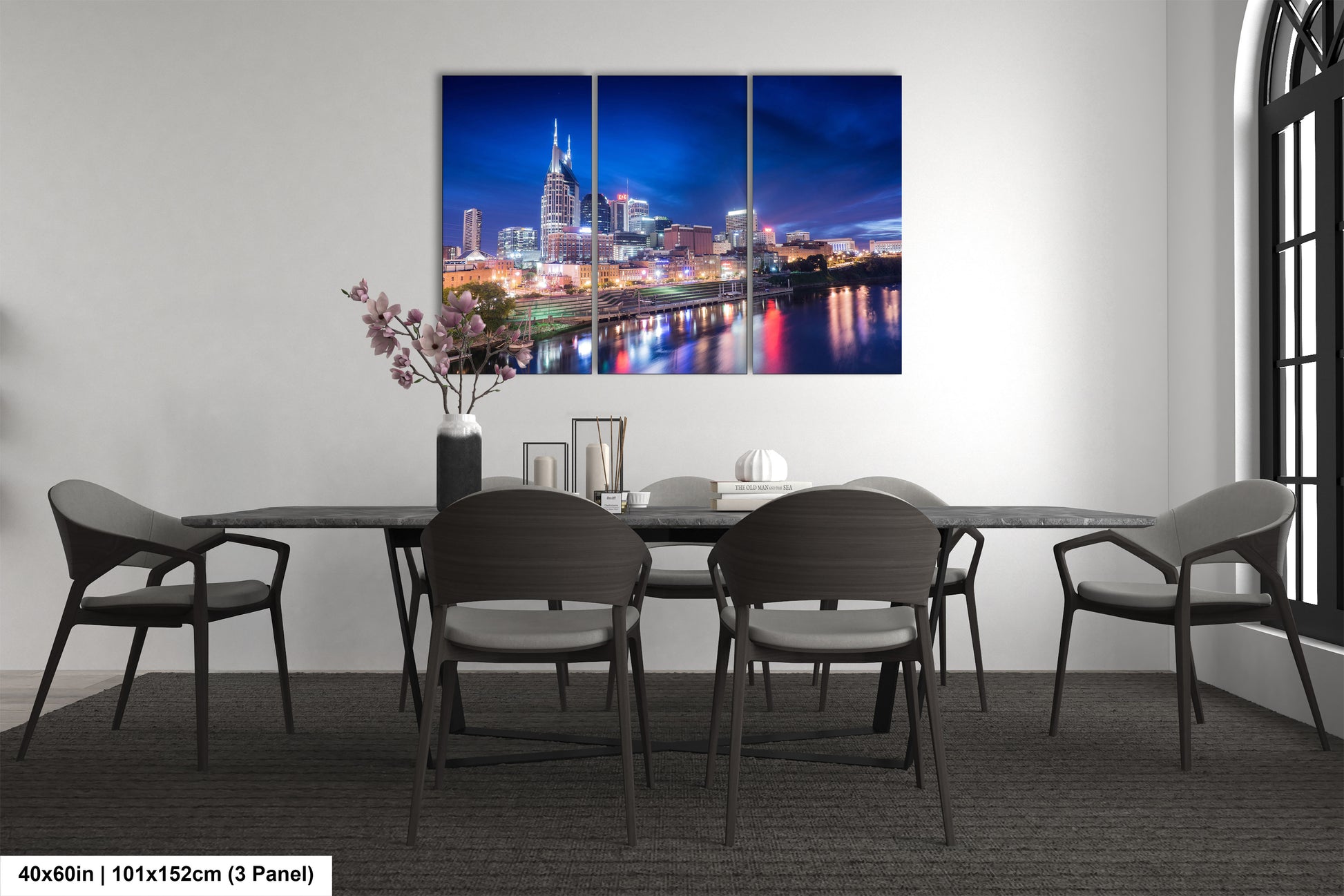 a dining room table with chairs and a painting on the wall