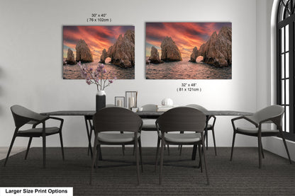 a dining room table with four chairs and two pictures on the wall
