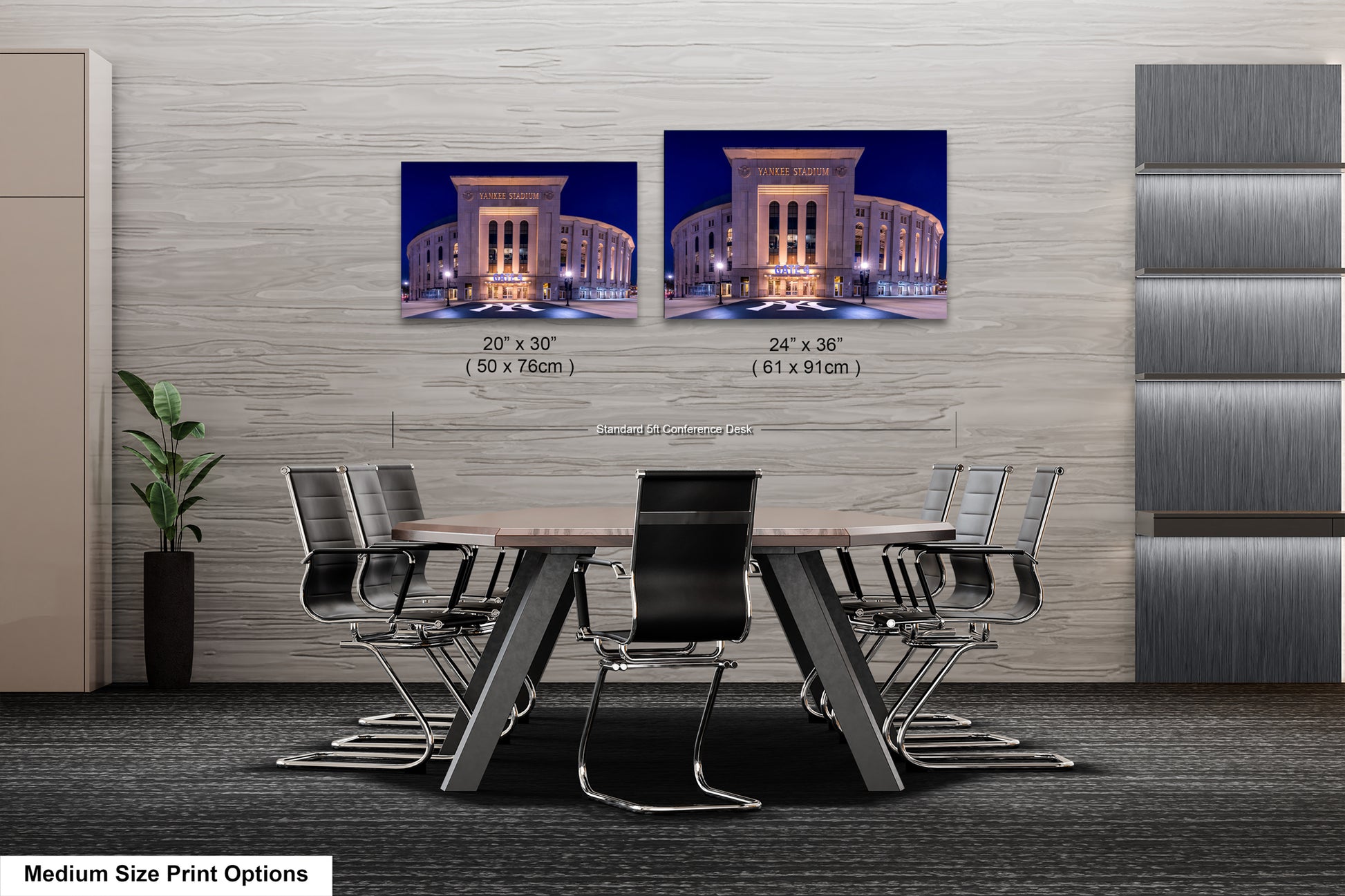 a modern office space with a large wooden table surrounded by black chairs. Two framed photographs of a building are displayed on the wall above the table.