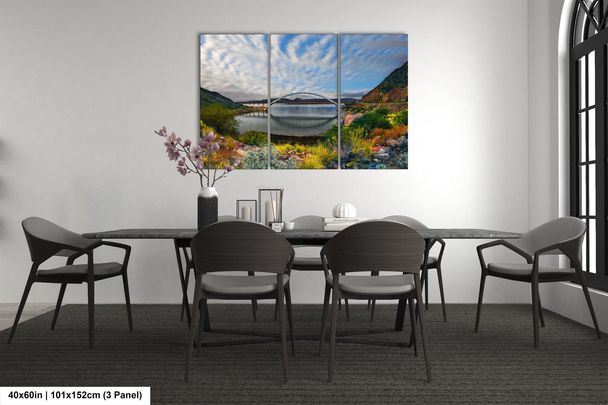 a dining room table with chairs and a painting on the wall