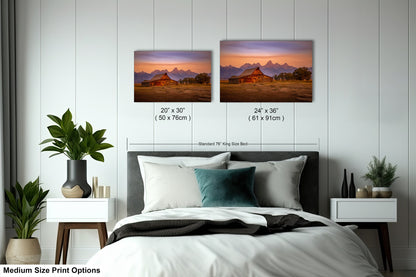 a bed with two pictures on the wall above it
