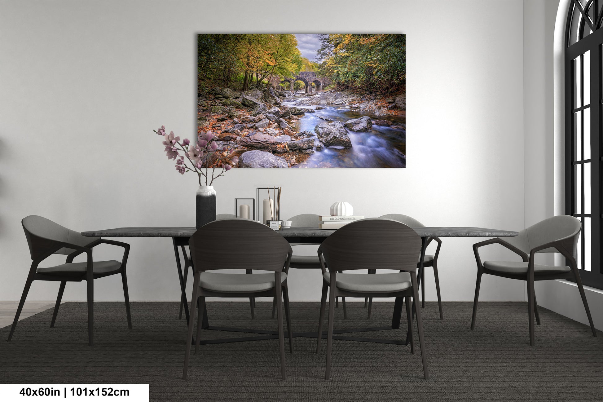 a room with a table and chairs and a painting on the wall