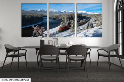 A modern dining room with a large, three-panel landscape painting depicting a snowy mountain scene with a train traveling through it.