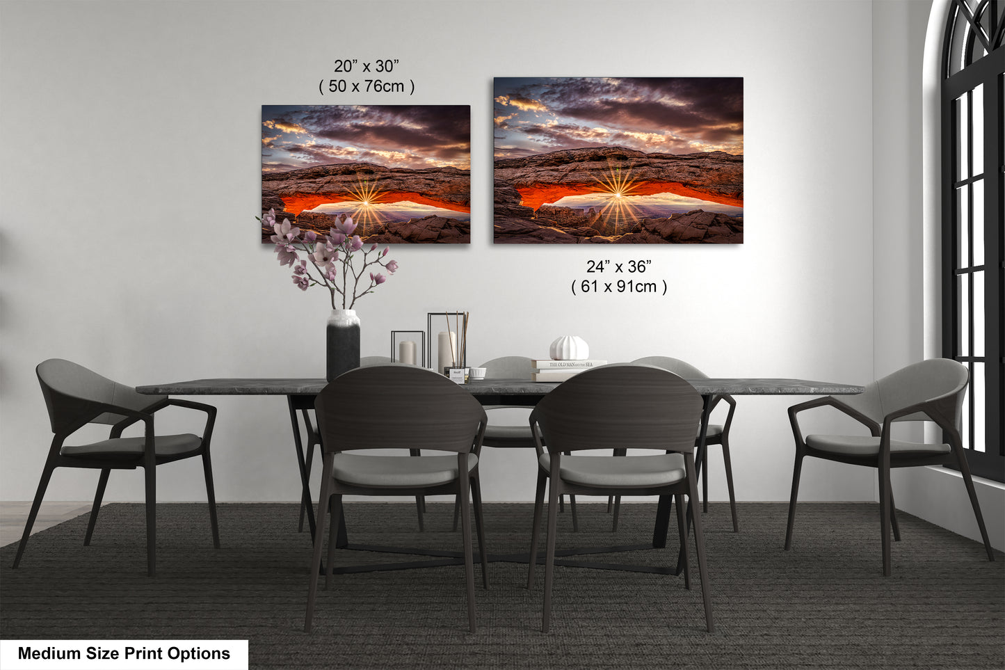 a dining room table with four chairs and a vase of flowers