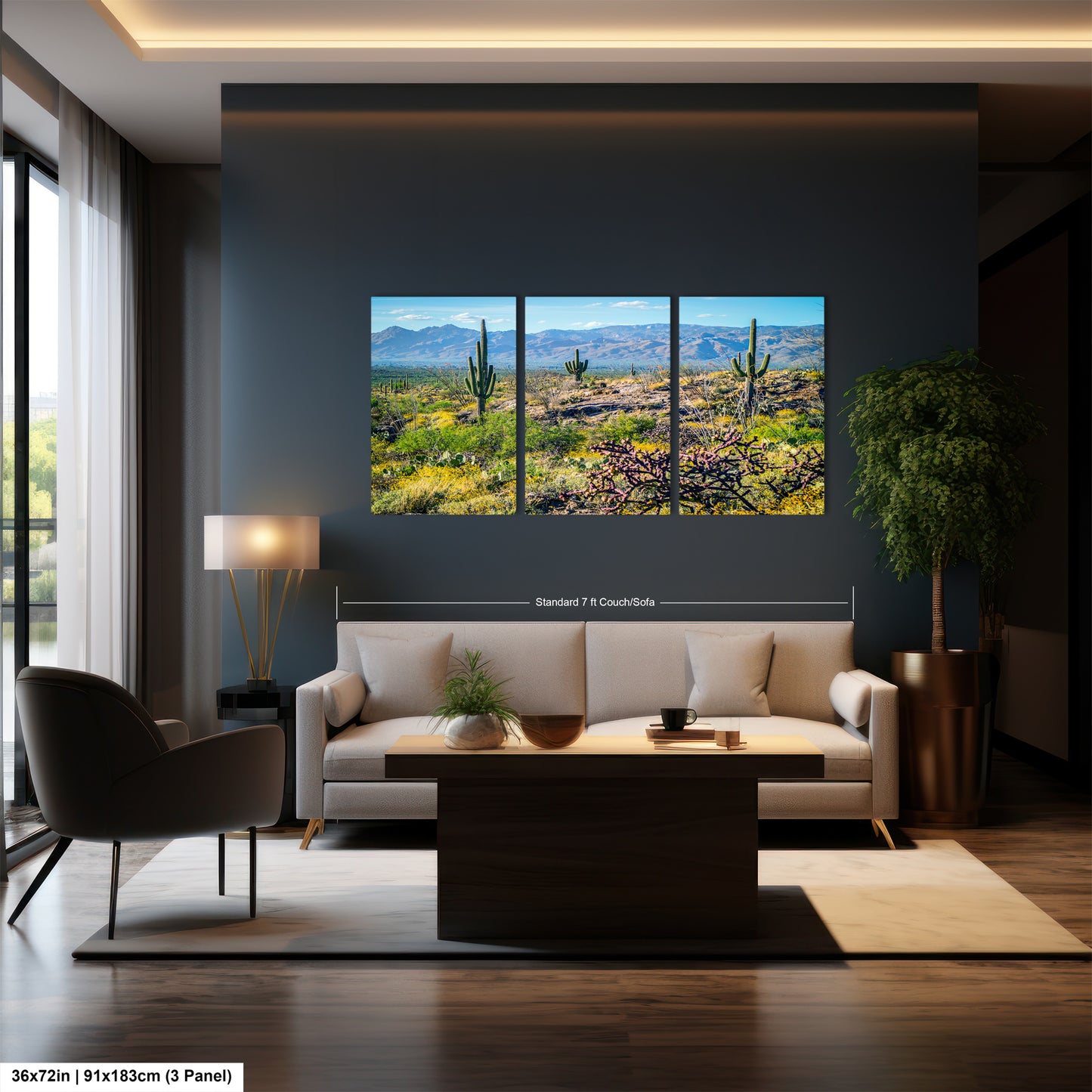 A modern living room with a large wall-mounted painting depicting a desert landscape with cacti and mountains. The room has a gray sofa, a wooden coffee table, and a large window overlooking the desert.