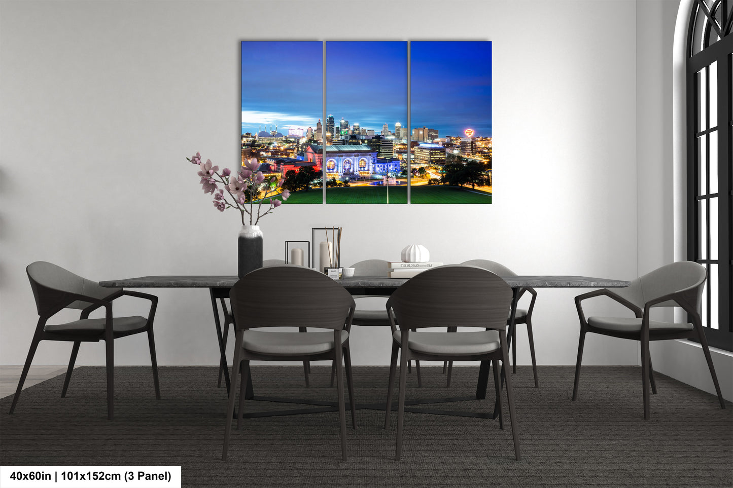 a dining room table with chairs and a painting on the wall