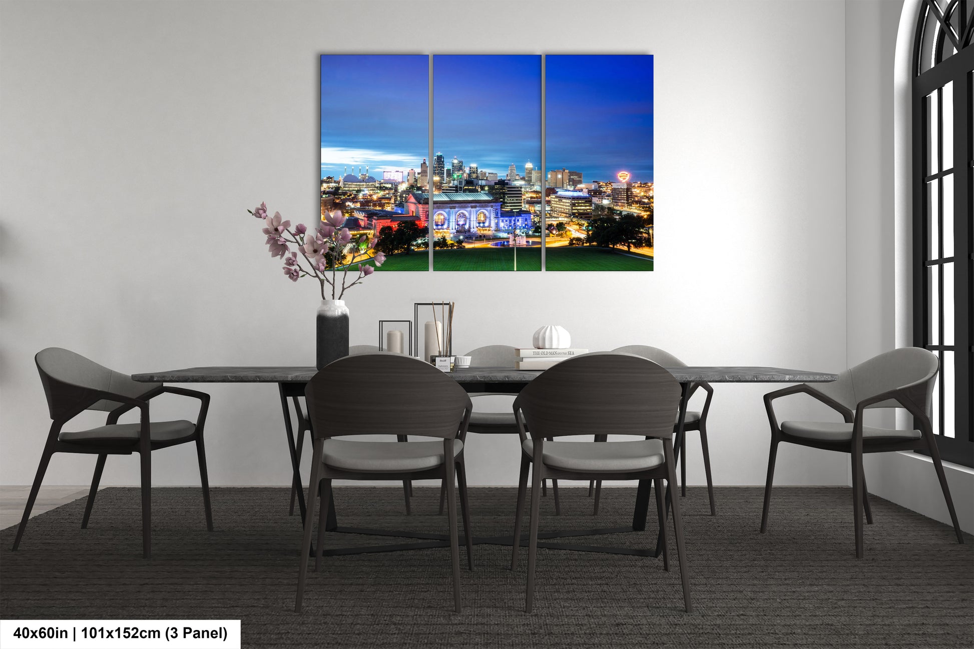 a dining room table with chairs and a painting on the wall