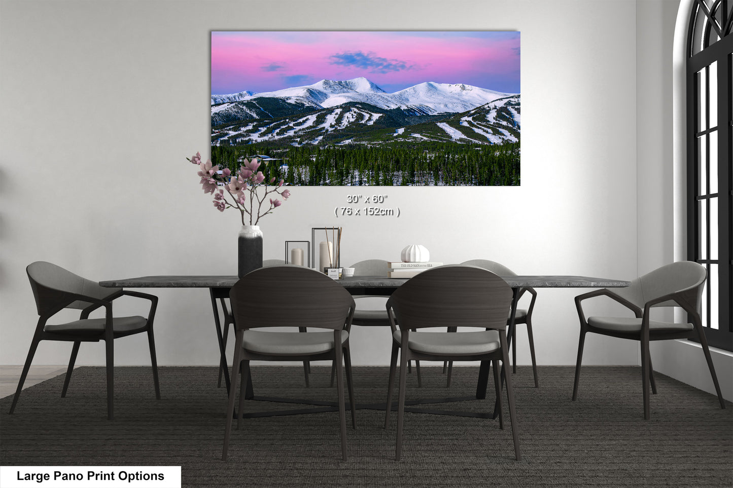a dining room table with chairs and a painting on the wall