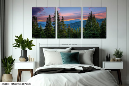 a bedroom with a large, three-panel landscape painting hanging on the wall above the bed. The painting depicts a scenic mountain landscape with pine trees and a colorful sunset sky.