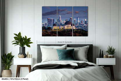 a bedroom with a large bed and a night view of a city