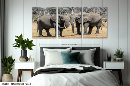 a couple of elephants standing next to each other on a bed