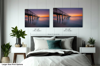 a bedroom with a bed and two pictures on the wall