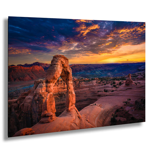 a rock formation in the desert with a sunset in the background