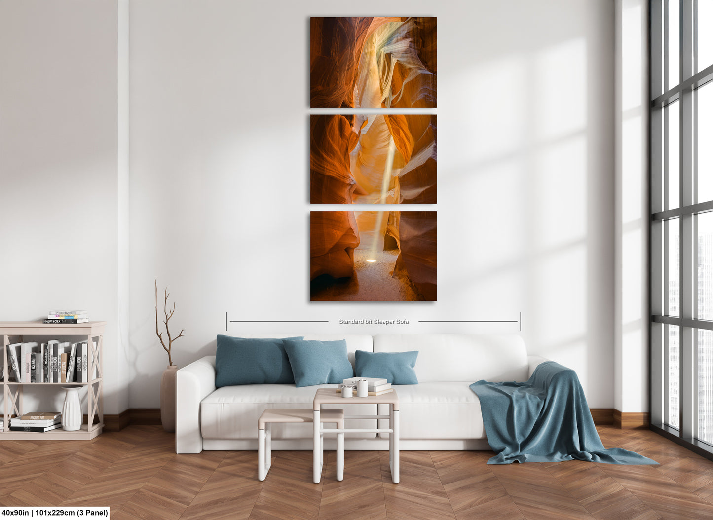 a living room with a white couch and three paintings on the wall
