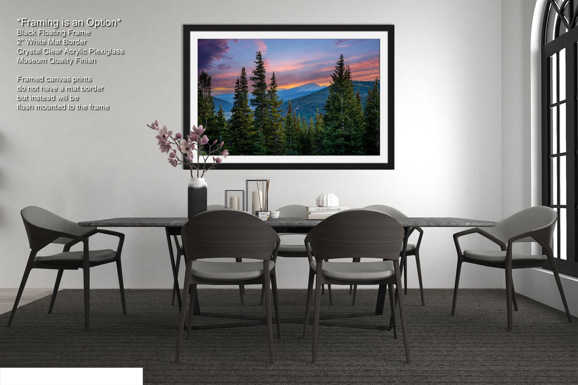 a modern dining room with a large framed landscape painting hanging on the wall above a black dining table surrounded by six chairs. The painting depicts a serene mountain landscape with a colorful sunset sky.