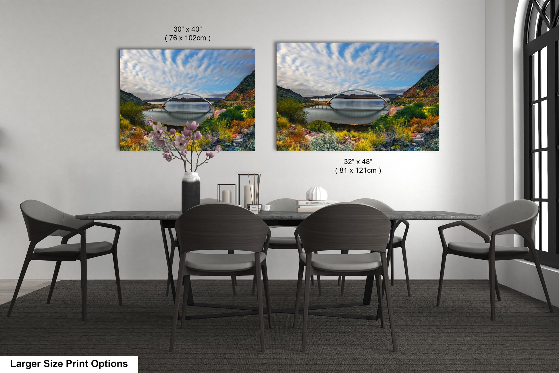a dining room table with four chairs and two pictures on the wall