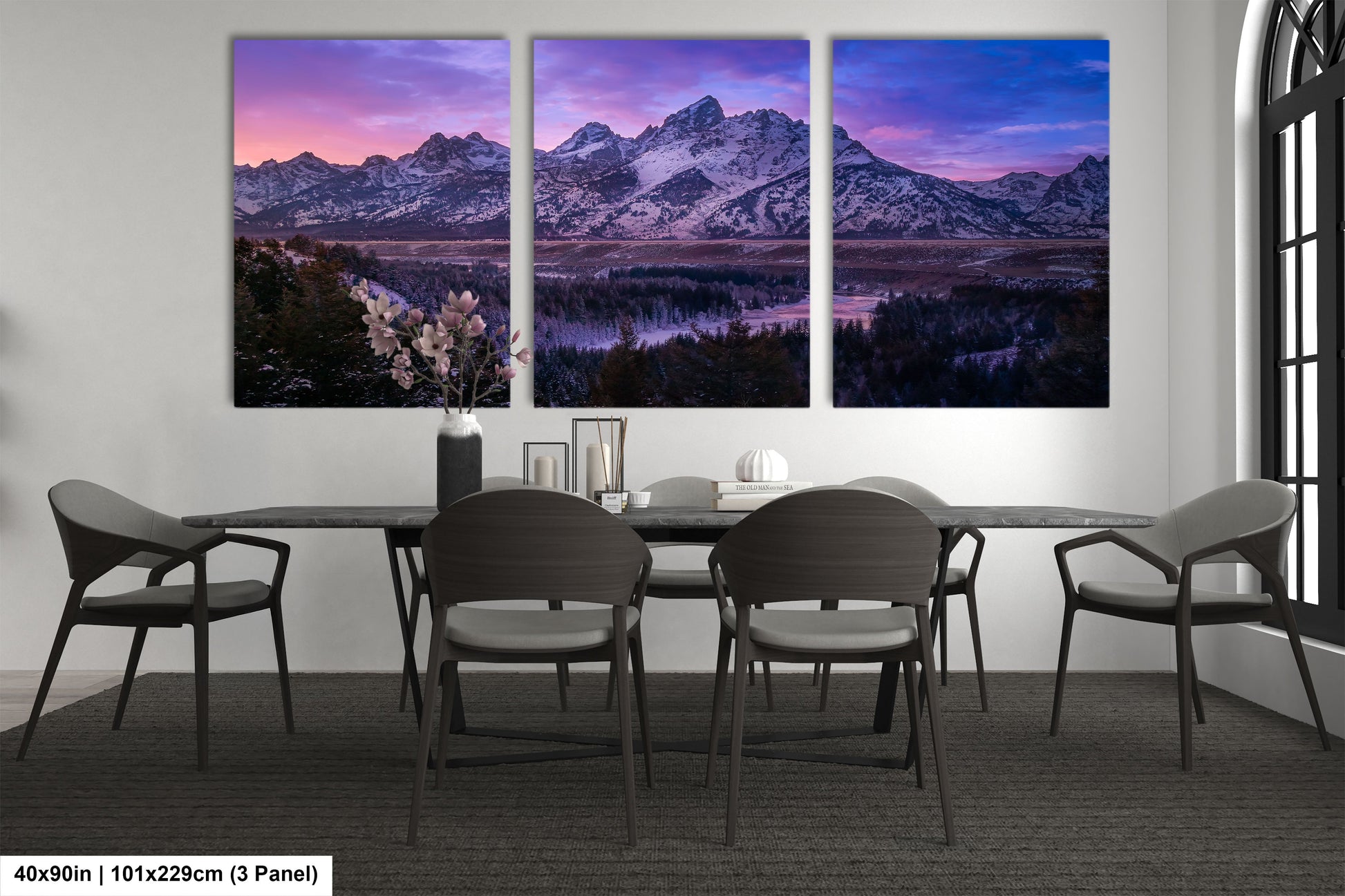 a dining room table with four chairs and three paintings on the wall