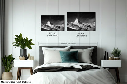 a bed with two pictures on the wall above it