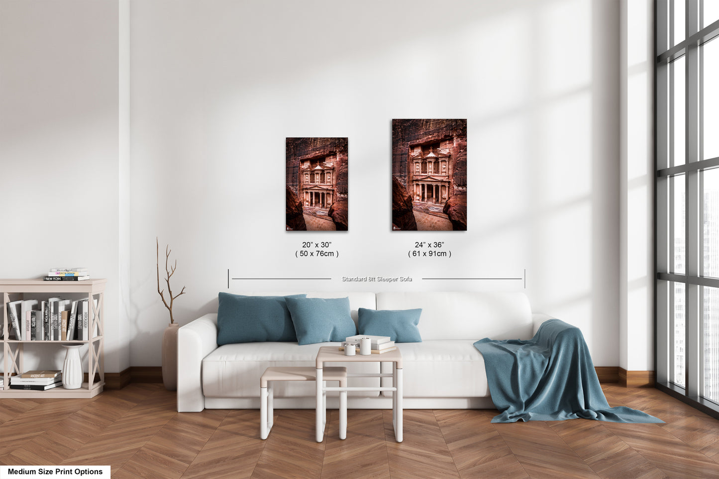 a living room with a white couch and two pictures on the wall