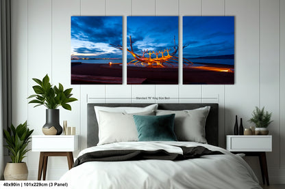 a bed room with a neatly made bed and three paintings on the wall