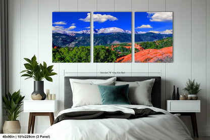 a bed room with a neatly made bed and three pictures on the wall