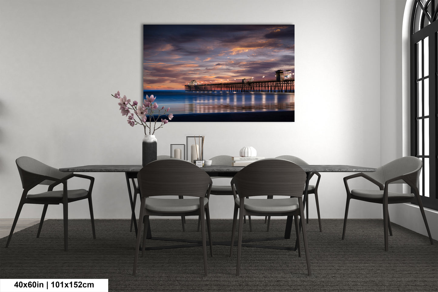 a dining room table with chairs and a painting on the wall