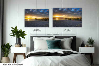 a bed with two pictures on the wall above it