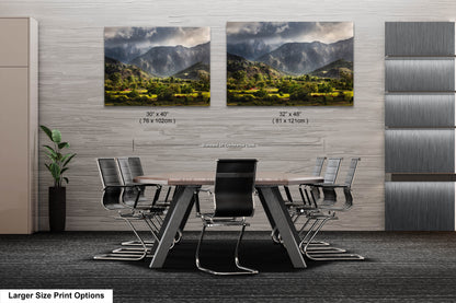 a dining room table with chairs in front of two pictures of mountains