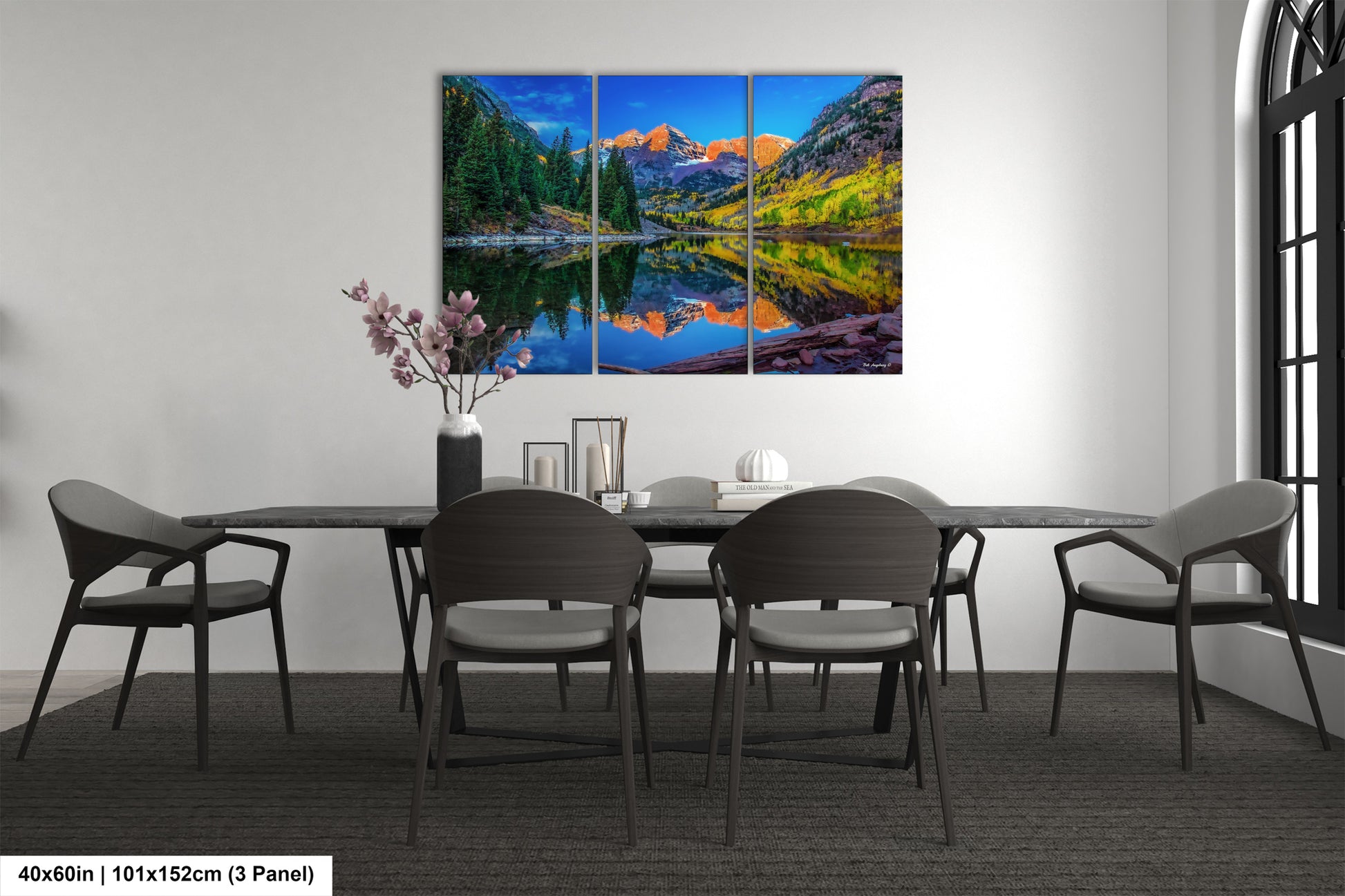 a dining room table with chairs and a painting on the wall